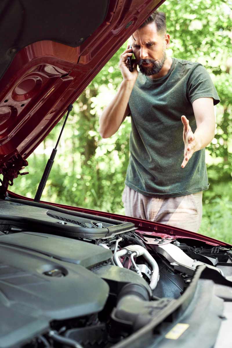 Junger Mann prüft Getriebeschaden bei Schrottauto Ankauf Ahrensburg